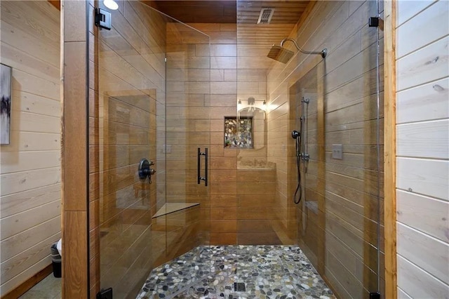 bathroom with wooden walls and a shower with shower door