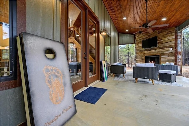 view of patio with an outdoor living space with a fireplace and ceiling fan