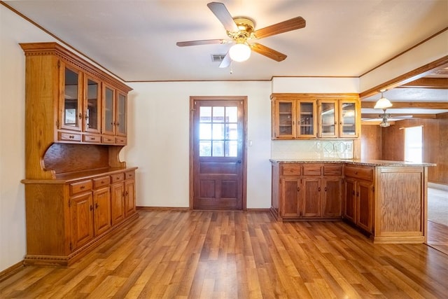 kitchen with tasteful backsplash, crown molding, light hardwood / wood-style flooring, kitchen peninsula, and ceiling fan