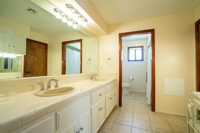 bathroom featuring tile patterned flooring, vanity, and toilet