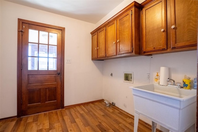 clothes washing area with sink, cabinets, washer hookup, hookup for a gas dryer, and light wood-type flooring