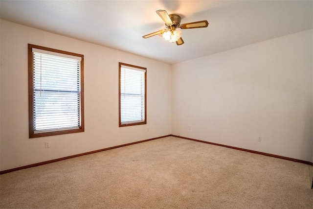 unfurnished room with a healthy amount of sunlight, light carpet, and ceiling fan