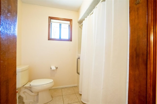 bathroom with curtained shower, tile patterned floors, and toilet