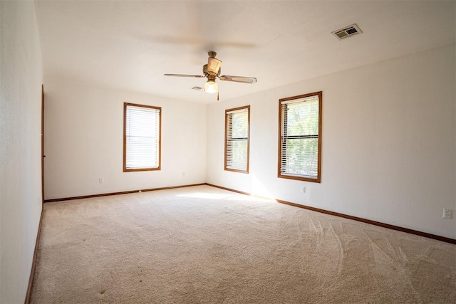 spare room featuring light colored carpet and ceiling fan