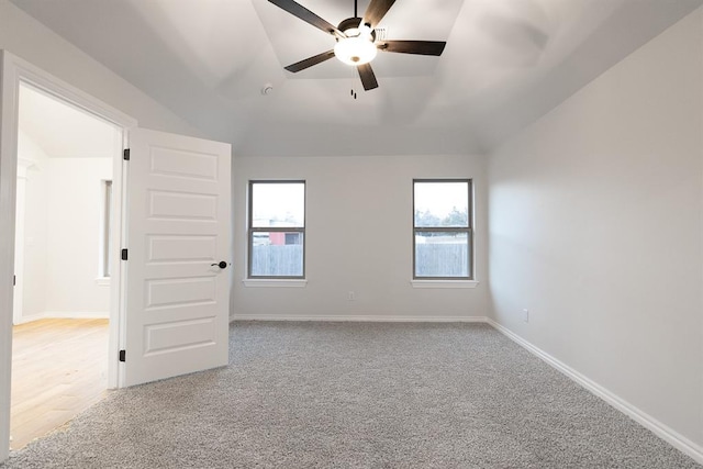 unfurnished room with vaulted ceiling, a wealth of natural light, and baseboards