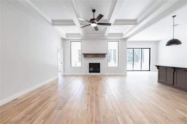 14001 Birch Ln, Edmond, OK 73049 - unfurnished living room with light wood finished floors, beamed ceiling, a stone fireplace, a ceiling fan, and coffered ceiling