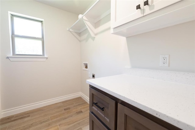 14001 Birch Ln, Edmond, OK 73049 - washroom featuring hookup for an electric dryer, washer hookup, light wood-style floors, and cabinet space