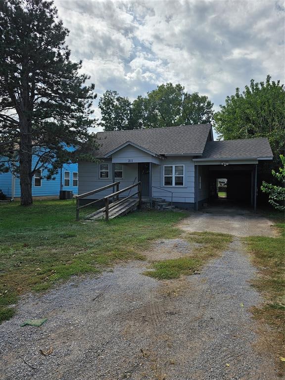 view of front of property featuring a carport and central AC unit