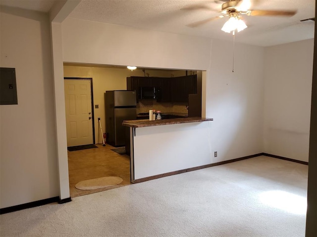 kitchen with light carpet, electric panel, ceiling fan, appliances with stainless steel finishes, and kitchen peninsula