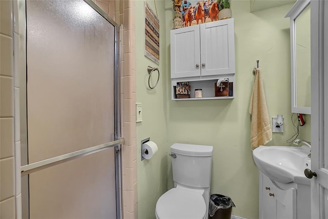 bathroom with vanity, toilet, and a shower with shower door