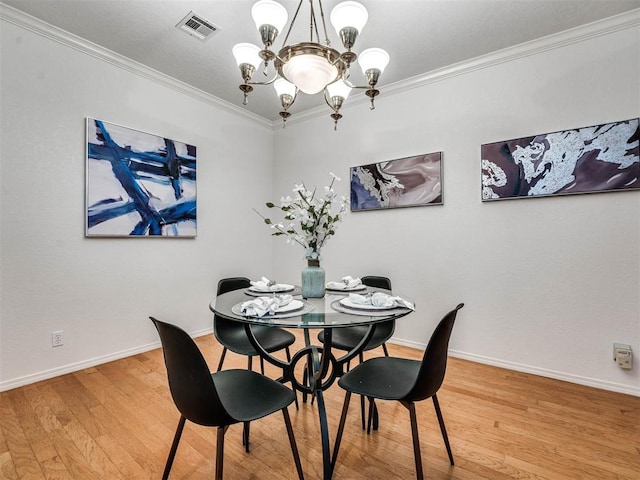 dining room featuring hardwood / wood-style floors, crown molding, and a notable chandelier