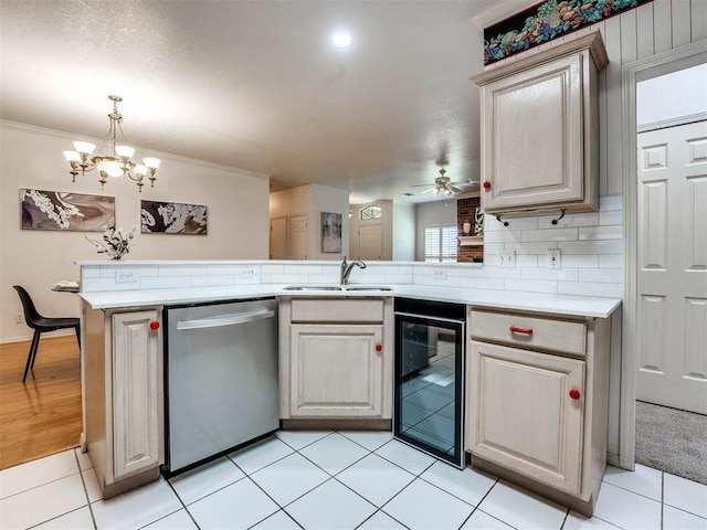 kitchen featuring dishwasher, sink, beverage cooler, kitchen peninsula, and ceiling fan with notable chandelier