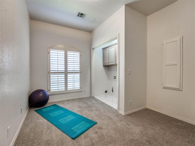 exercise room featuring light carpet