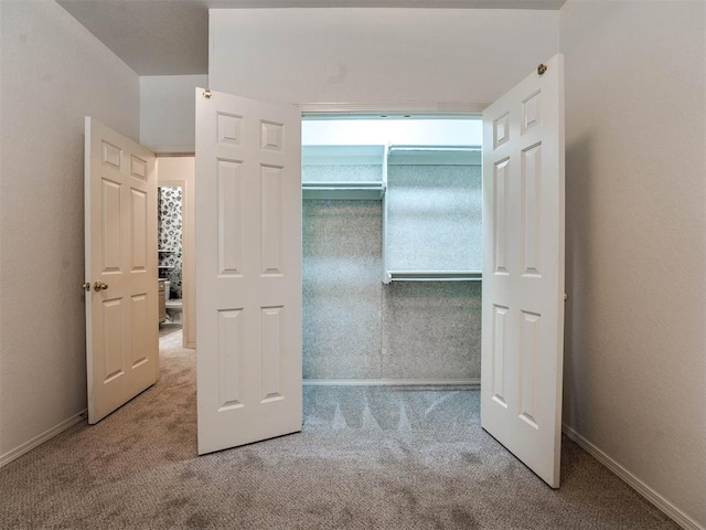 unfurnished bedroom with light carpet and a closet