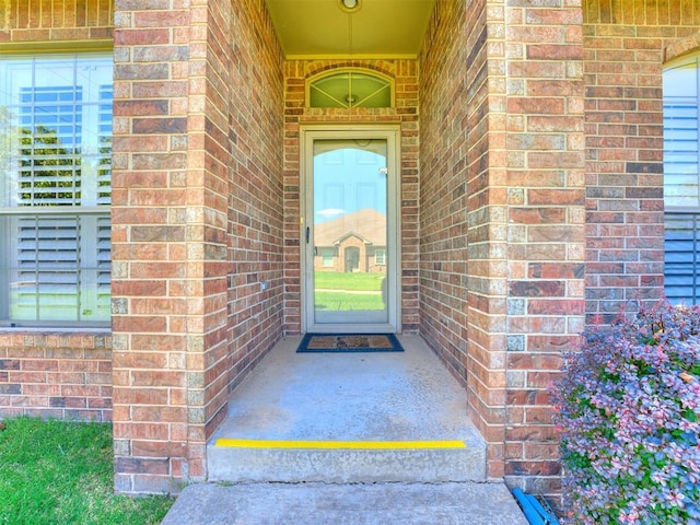 view of exterior entry with brick siding