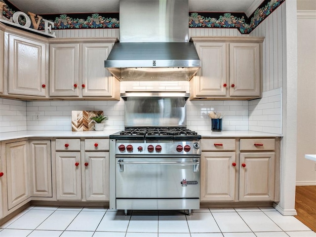 kitchen with light countertops, wall chimney range hood, high end stainless steel range oven, and decorative backsplash