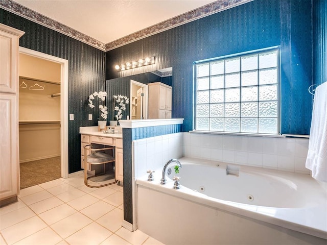 bathroom featuring wallpapered walls, tile patterned floors, a jetted tub, a spacious closet, and vanity