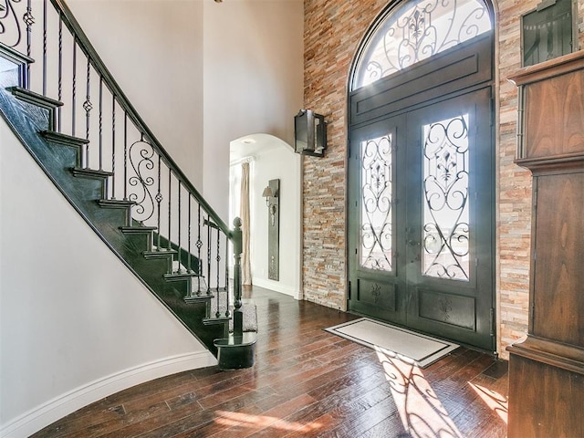 entrance foyer with a high ceiling, dark hardwood / wood-style floors, and french doors