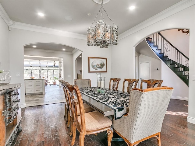 dining area with dark hardwood / wood-style flooring, an inviting chandelier, and ornamental molding