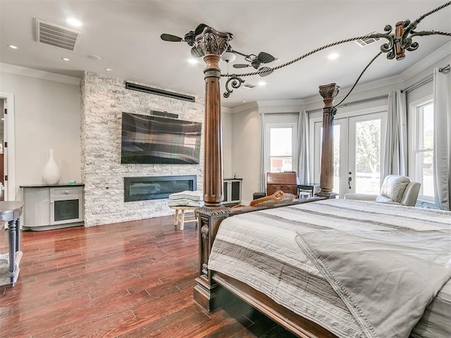 bedroom with a fireplace, access to exterior, hardwood / wood-style flooring, and crown molding