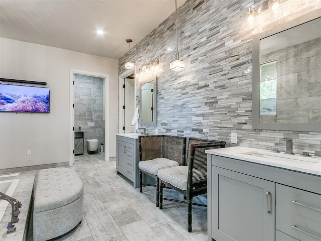 bathroom with vanity, toilet, and tile walls