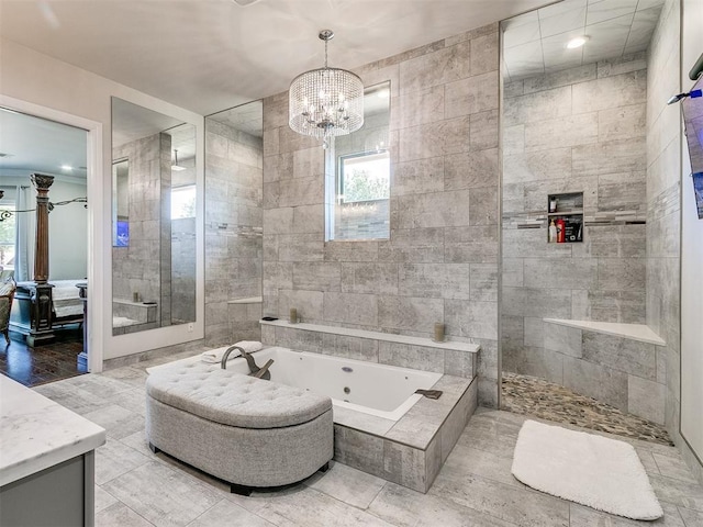 bathroom with a notable chandelier, shower with separate bathtub, vanity, and tile walls