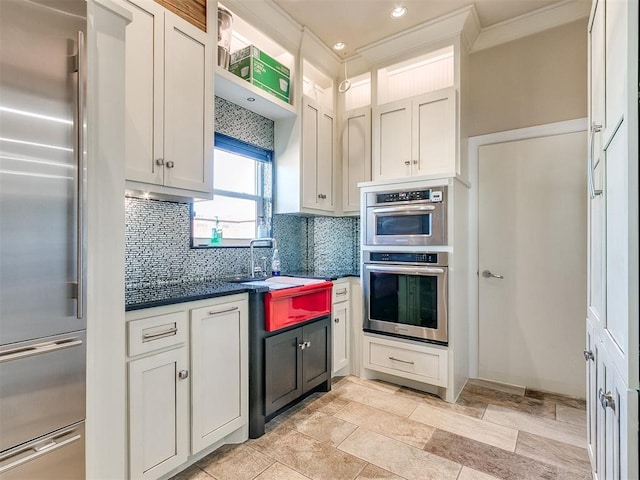 kitchen featuring white cabinets, sink, backsplash, and appliances with stainless steel finishes