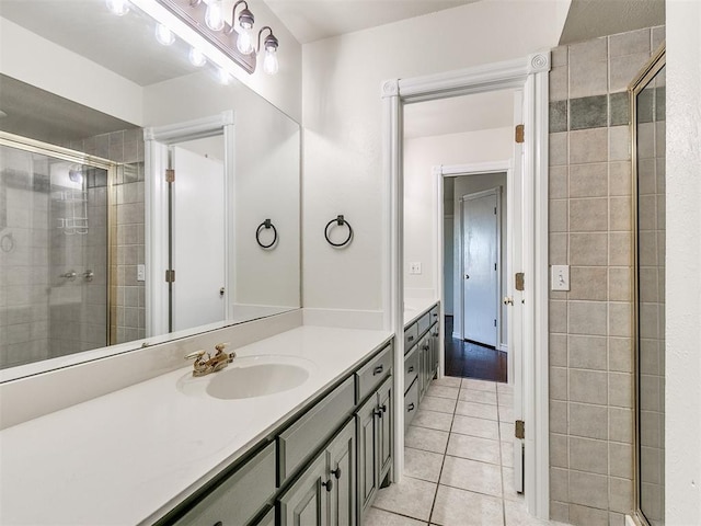 bathroom featuring tile patterned flooring, vanity, and a shower with shower door