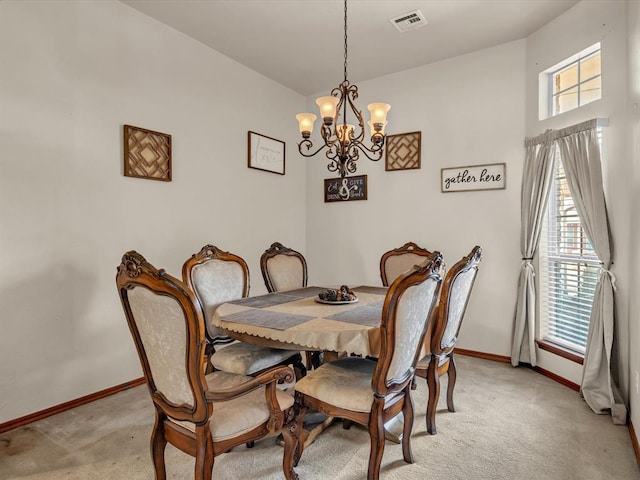 dining space featuring a wealth of natural light, light colored carpet, and a notable chandelier