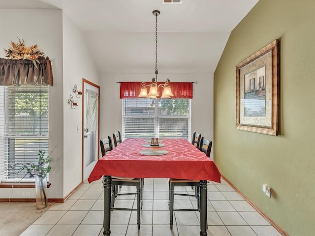 tiled dining room featuring a wealth of natural light and vaulted ceiling