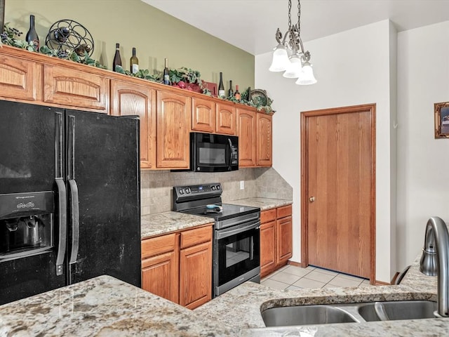 kitchen featuring black appliances, sink, light stone countertops, tasteful backsplash, and light tile patterned flooring