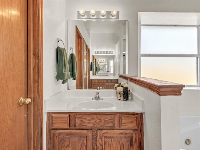 bathroom with a washtub and vanity