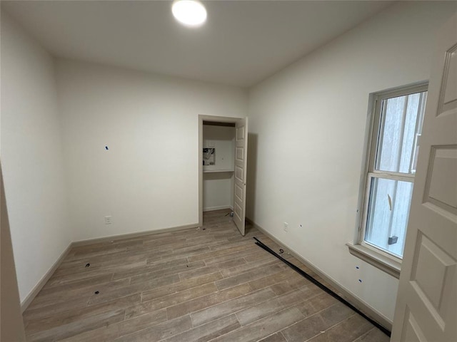 unfurnished bedroom featuring light hardwood / wood-style flooring and multiple windows