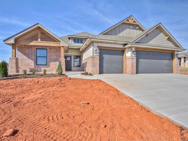 view of front facade with board and batten siding, brick siding, driveway, and an attached garage