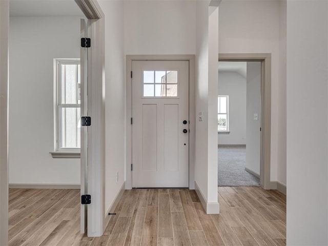 foyer featuring light wood-style flooring and baseboards