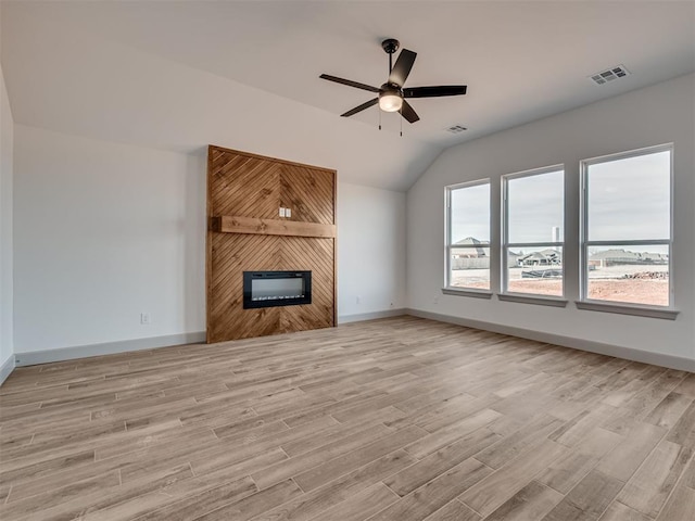 unfurnished living room featuring vaulted ceiling, visible vents, a fireplace, and light wood finished floors