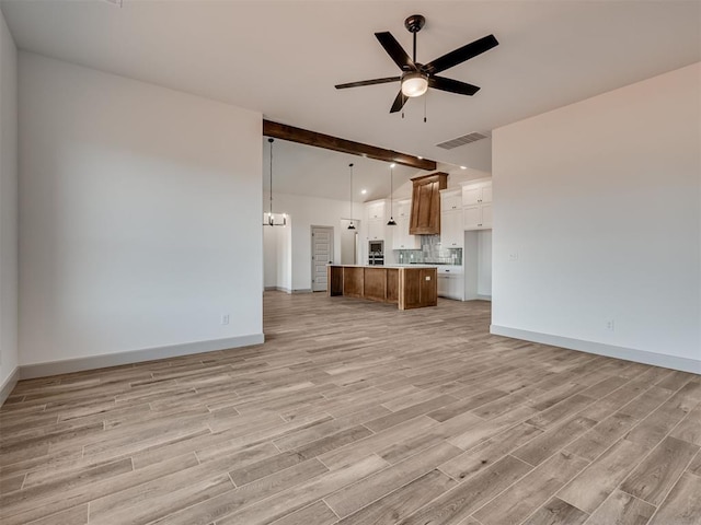 unfurnished living room featuring visible vents, baseboards, a ceiling fan, light wood-style floors, and beamed ceiling