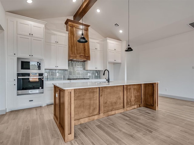 kitchen with lofted ceiling with beams, visible vents, light wood-style floors, appliances with stainless steel finishes, and decorative backsplash