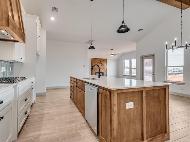 kitchen featuring lofted ceiling, light countertops, appliances with stainless steel finishes, a sink, and light wood-type flooring