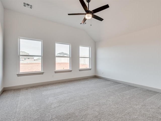 empty room featuring baseboards, visible vents, light colored carpet, lofted ceiling, and ceiling fan