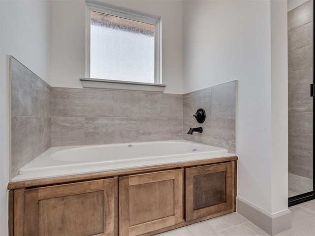 full bath featuring a garden tub and tile patterned floors