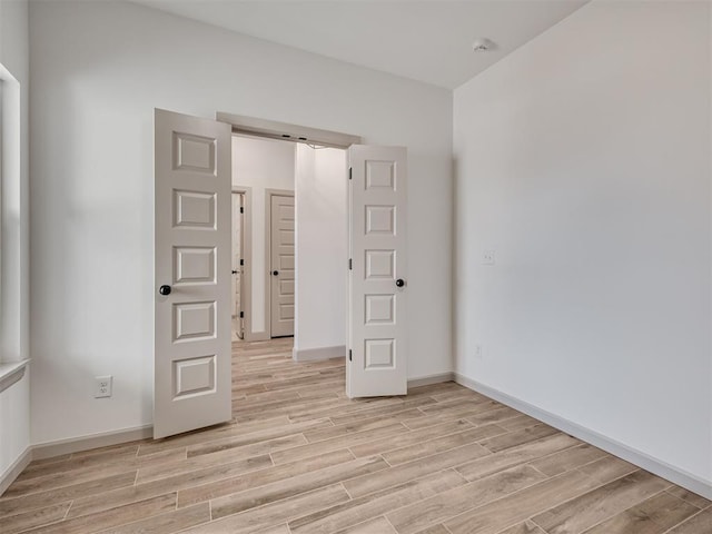 empty room with light wood-style floors and baseboards