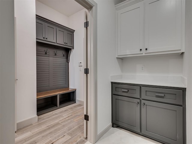 mudroom featuring light wood-style flooring and baseboards