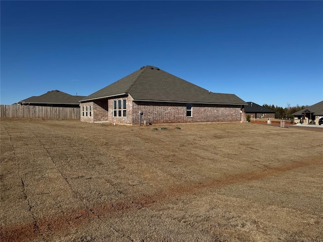 view of home's exterior with brick siding and fence