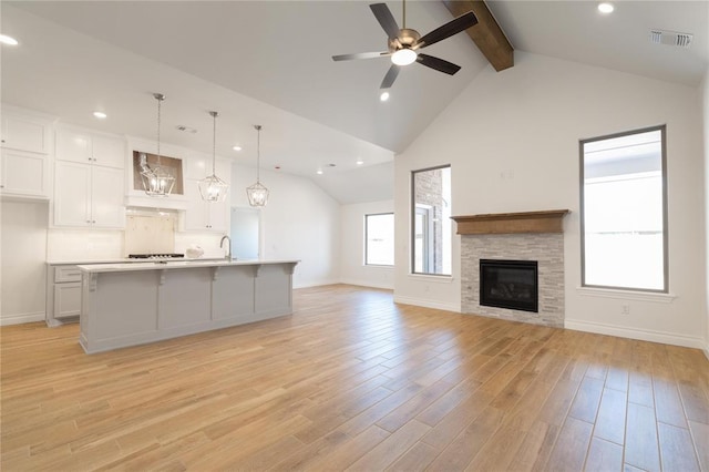 unfurnished living room with recessed lighting, baseboards, and beamed ceiling