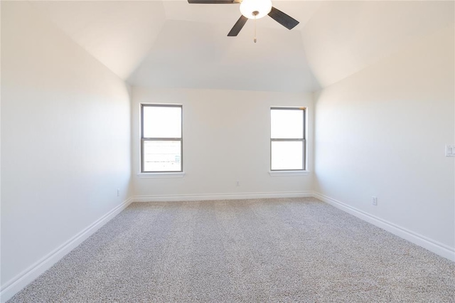 spare room featuring a wealth of natural light, light carpet, vaulted ceiling, and a ceiling fan