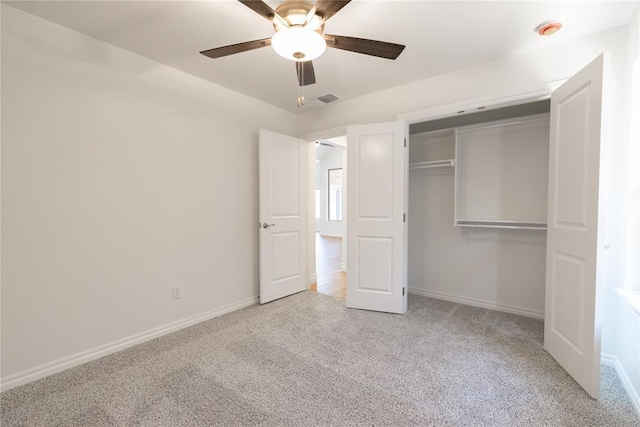 unfurnished bedroom with a closet, a ceiling fan, visible vents, carpet floors, and baseboards