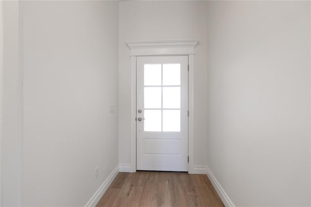 entryway with light wood-type flooring, baseboards, and plenty of natural light