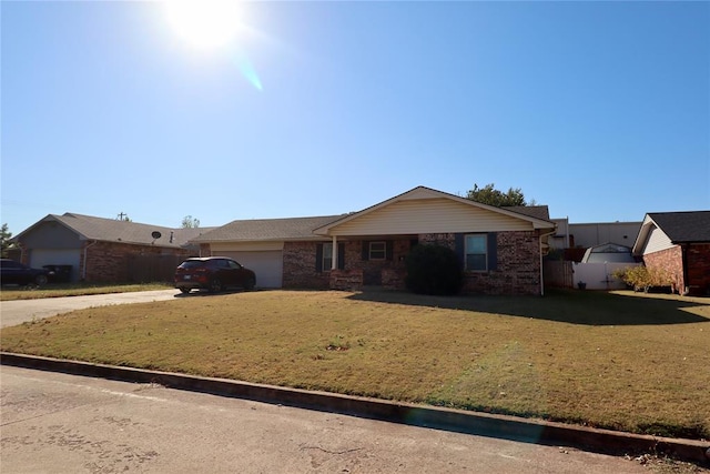 ranch-style house featuring a garage and a front lawn