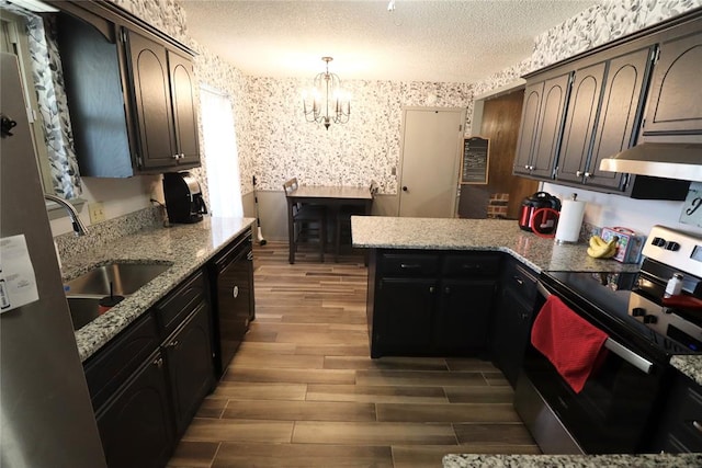 kitchen featuring dark brown cabinetry, ventilation hood, pendant lighting, a textured ceiling, and stainless steel range with electric stovetop